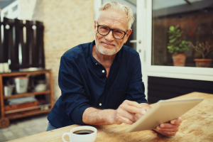 An old man holding a document on his office