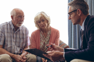 Insurance broker showing paperwork to a senior citizen couple