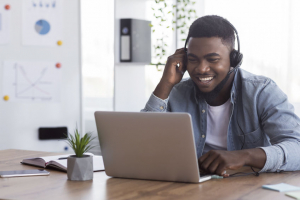 Man watching a webinar on his laptop with headphones