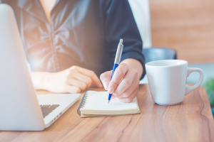 Business woman writing in a notebook