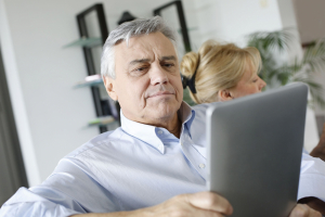 Senior citizen reading news on a tablet