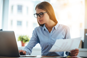 A woman holding a piece of white paper in the office