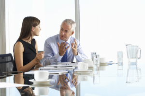 An old man and a woman having a conversation inside the office.