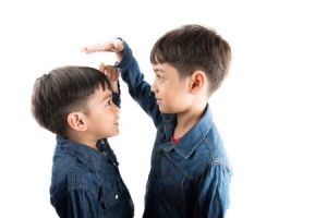 siblings measuring how tall they are