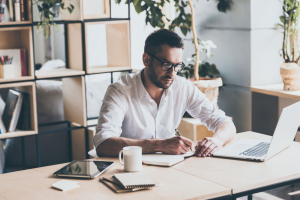 Business man taking notes while working in an office