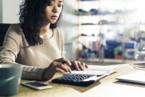 Female accountant using a calculator in an office