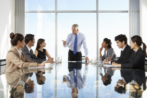 Group of business people having board meeting around glass table
