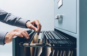 Office clerk searching for files in a filing cabinet