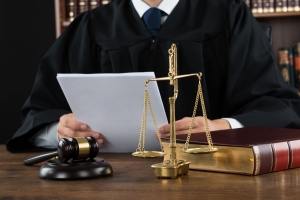 Judge reading documents at a desk in a courtroom