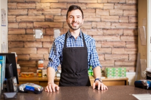 Business owner standing at checkout counter 