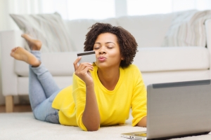 Woman at home with laptop and debit card