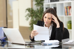 Worried businesswoman reading a notification sitting in a desktop at office