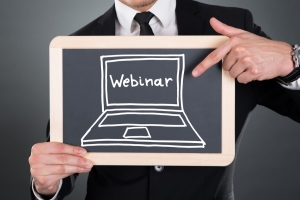 Business man holding a chalkboard with the word webinar